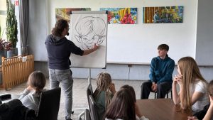 Read more about the article Spotkanie autorskie z karykaturzystą Szymonem Telukiem 🎓📙